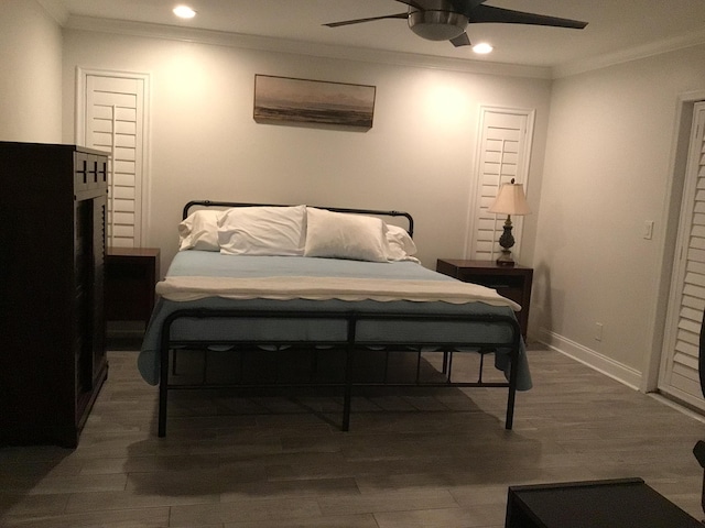 bedroom with recessed lighting, baseboards, crown molding, and wood finished floors