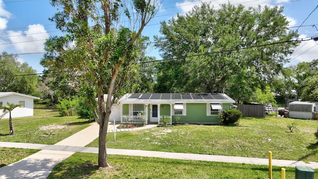 775 Sandia Ave, Port Saint Lucie, FL 34983 - view of front of property featuring covered porch, fence, a front lawn, and roof mounted solar panels