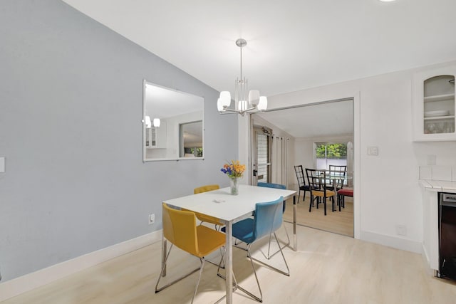 775 Sandia Ave, Port Saint Lucie, FL 34983 - dining area featuring baseboards, light wood-type flooring, a notable chandelier, and lofted ceiling