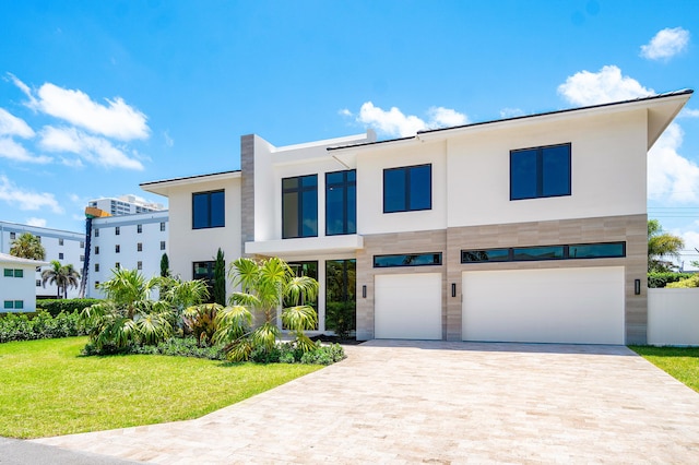 368 Churchill Rd, West Palm Beach, FL 33405 - contemporary home with a front lawn, decorative driveway, a garage, and stucco siding