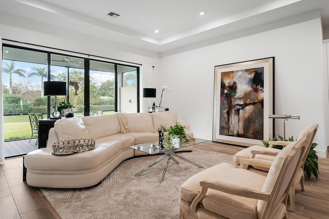 living area with recessed lighting, visible vents, baseboards, and wood finished floors