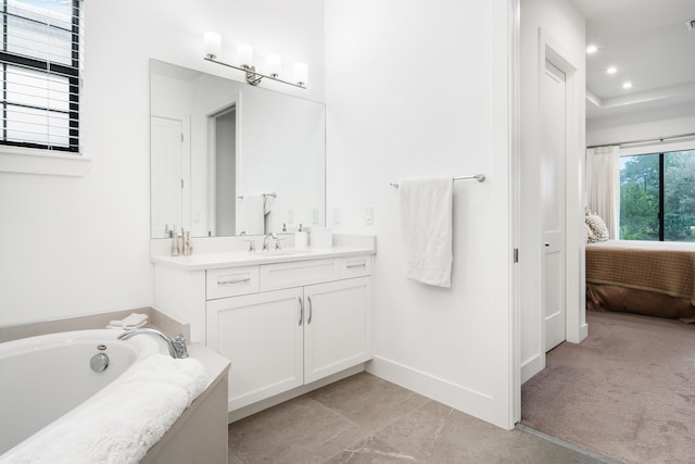 ensuite bathroom with baseboards, a garden tub, recessed lighting, ensuite bathroom, and vanity