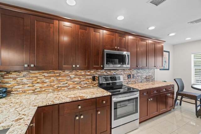 9 Stratford Dr Unit D, Boynton Beach, FL 33436 - kitchen featuring light stone counters, visible vents, tasteful backsplash, and appliances with stainless steel finishes