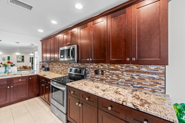 9 Stratford Dr Unit D, Boynton Beach, FL 33436 - kitchen with visible vents, light stone counters, light tile patterned floors, decorative backsplash, and stainless steel appliances