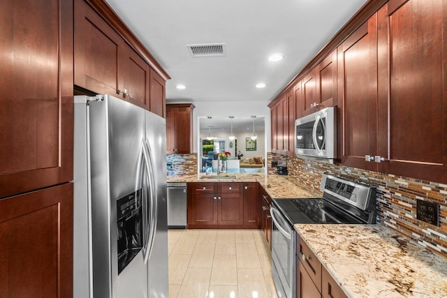 9 Stratford Dr Unit D, Boynton Beach, FL 33436 - kitchen with light stone counters, visible vents, a sink, appliances with stainless steel finishes, and backsplash