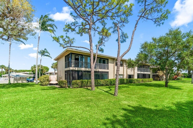 9 Stratford Dr Unit D, Boynton Beach, FL 33436 - rear view of house with stucco siding and a lawn