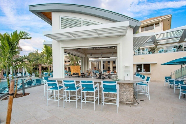 9 Stratford Dr Unit D, Boynton Beach, FL 33436 - view of swimming pool featuring outdoor dry bar and a patio area