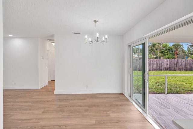 12938 Ellison Wilson Rd, North Palm Beach, FL 33408 - unfurnished dining area featuring a chandelier, baseboards, and light wood-style flooring