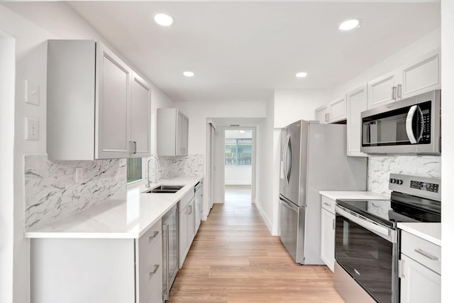 12938 Ellison Wilson Rd, North Palm Beach, FL 33408 - kitchen with stainless steel appliances, a sink, decorative backsplash, recessed lighting, and light wood finished floors