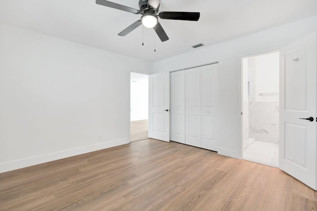 12938 Ellison Wilson Rd, North Palm Beach, FL 33408 - unfurnished bedroom featuring light wood-style flooring, baseboards, a closet, ensuite bathroom, and a ceiling fan