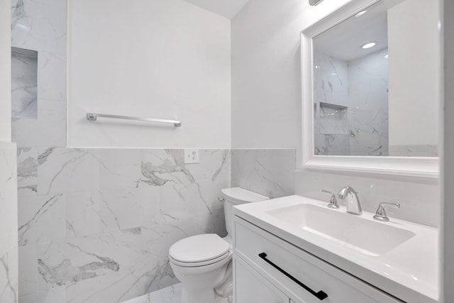 12938 Ellison Wilson Rd, North Palm Beach, FL 33408 - bathroom with toilet, vanity, tile walls, a wainscoted wall, and marble finish flooring