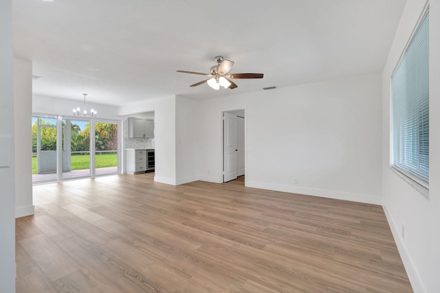 12938 Ellison Wilson Rd, North Palm Beach, FL 33408 - unfurnished living room with a chandelier, baseboards, light wood-style flooring, and a ceiling fan