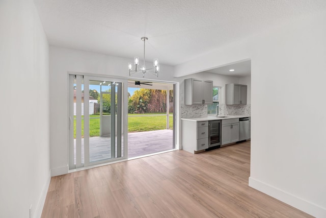 12938 Ellison Wilson Rd, North Palm Beach, FL 33408 - kitchen featuring gray cabinets, dishwasher, wine cooler, a sink, and a chandelier