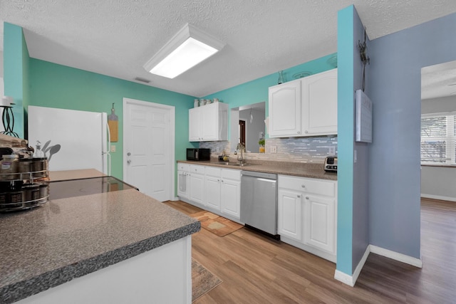 332 Smallwood Ave, Fort Pierce, FL 34982 - kitchen featuring light wood-type flooring, a sink, dark countertops, freestanding refrigerator, and dishwasher