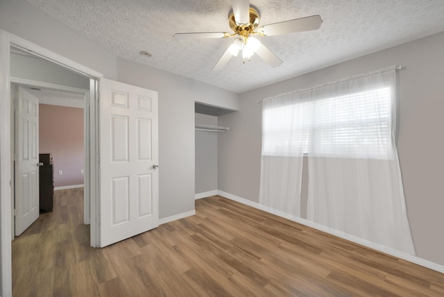 332 Smallwood Ave, Fort Pierce, FL 34982 - unfurnished bedroom featuring ceiling fan, baseboards, wood finished floors, a closet, and a textured ceiling