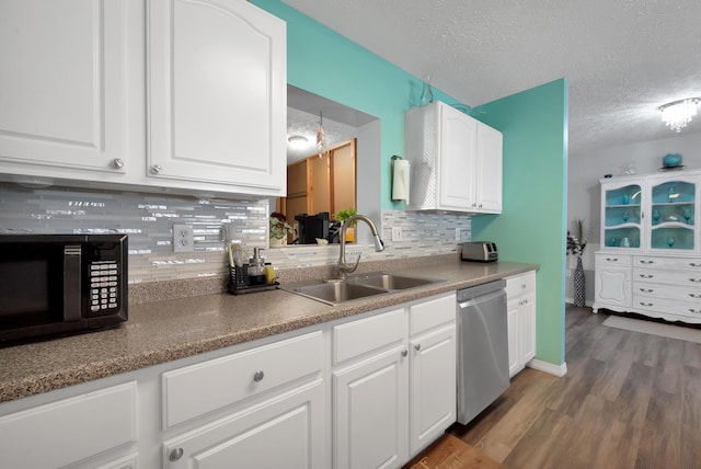 332 Smallwood Ave, Fort Pierce, FL 34982 - kitchen featuring black microwave, stainless steel dishwasher, wood finished floors, a textured ceiling, and a sink