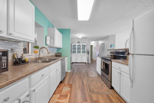 332 Smallwood Ave, Fort Pierce, FL 34982 - kitchen with a sink, stainless steel appliances, light wood-style floors, and white cabinetry