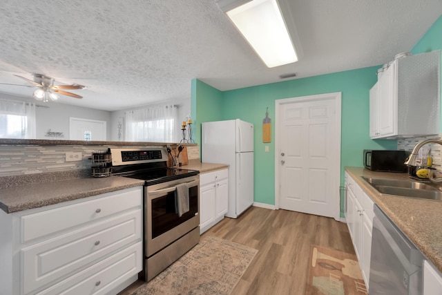 332 Smallwood Ave, Fort Pierce, FL 34982 - kitchen with light wood finished floors, visible vents, appliances with stainless steel finishes, white cabinets, and a sink