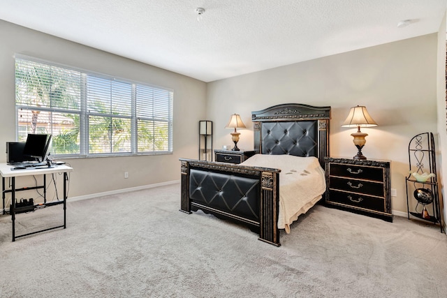 carpeted bedroom featuring baseboards and a textured ceiling