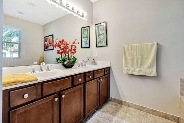 bathroom featuring a sink, visible vents, double vanity, and tile patterned floors