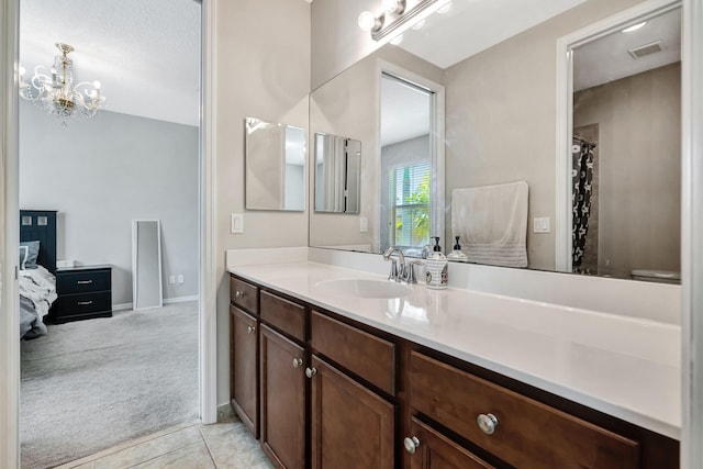 full bath with visible vents, baseboards, an inviting chandelier, tile patterned floors, and vanity