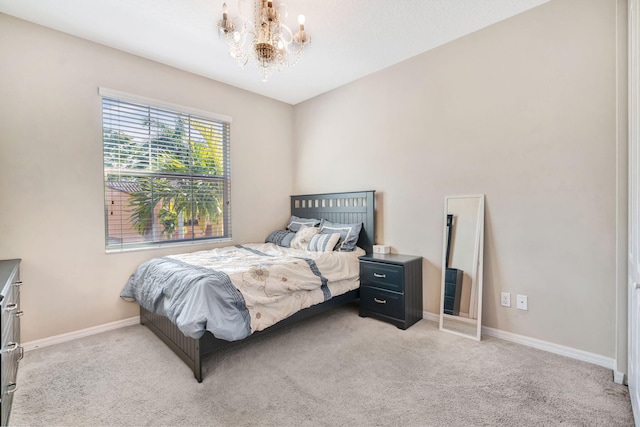 bedroom featuring a chandelier, light carpet, and baseboards