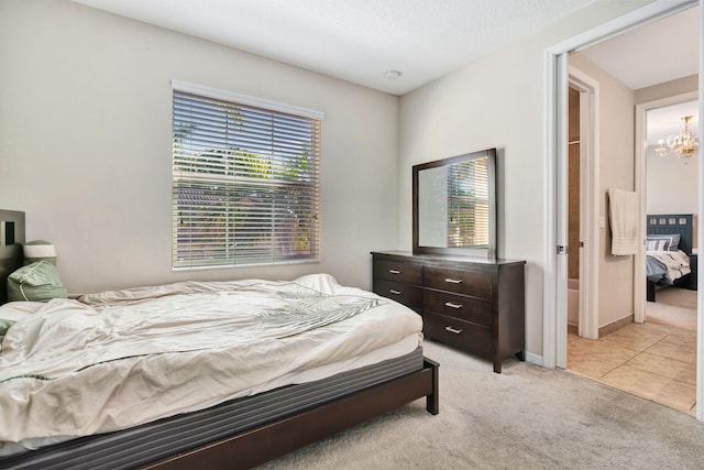 bedroom with light carpet, a chandelier, baseboards, and light tile patterned floors