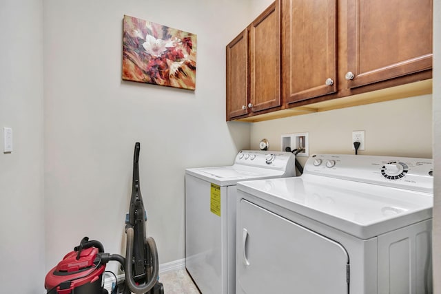 washroom featuring washer and dryer, cabinet space, and baseboards