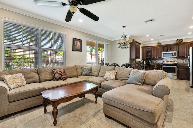 living room with light tile patterned floors, ceiling fan with notable chandelier, visible vents, and ornamental molding