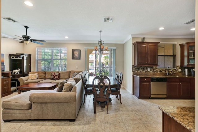 living area with recessed lighting, visible vents, and crown molding