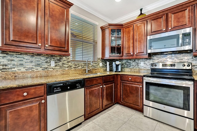 kitchen with backsplash, ornamental molding, appliances with stainless steel finishes, light tile patterned flooring, and a sink