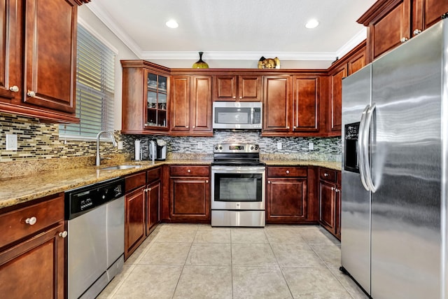 kitchen with crown molding, light stone counters, light tile patterned floors, stainless steel appliances, and a sink