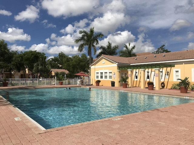 community pool featuring a patio and fence