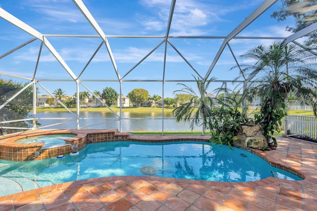 view of swimming pool featuring a patio, a pool with connected hot tub, glass enclosure, and a water view