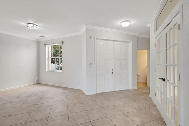 unfurnished bedroom featuring baseboards, light tile patterned floors, a closet, and ornamental molding