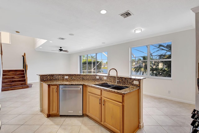 kitchen with visible vents, stone countertops, a kitchen island with sink, light tile patterned flooring, and a sink