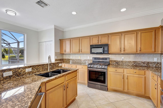 kitchen with black microwave, backsplash, visible vents, stainless steel range with gas stovetop, and a sink