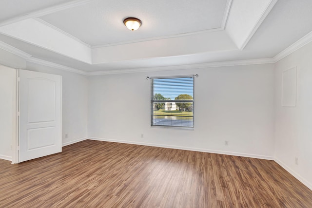 bedroom with visible vents, baseboards, crown molding, a tray ceiling, and wood finished floors