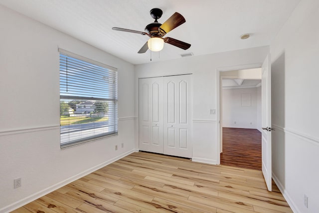 unfurnished bedroom with visible vents, light wood-style flooring, a closet, and baseboards