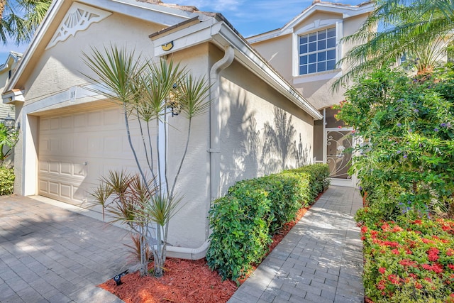 view of home's exterior featuring a garage, driveway, and stucco siding