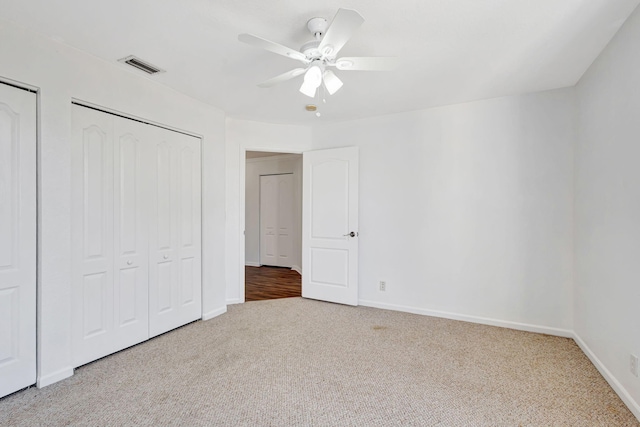unfurnished bedroom with baseboards, a ceiling fan, visible vents, and carpet floors