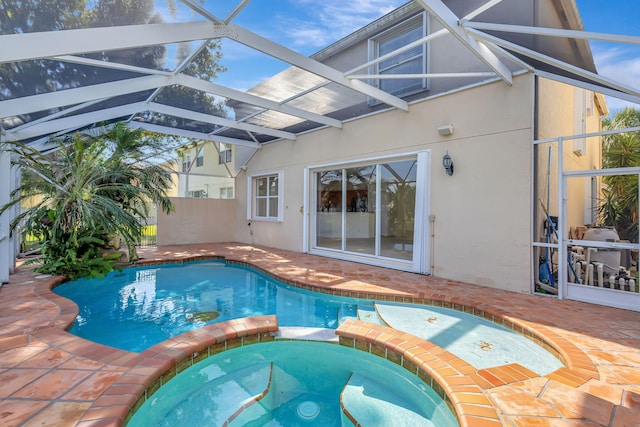 view of pool with a patio, a pool with connected hot tub, and glass enclosure