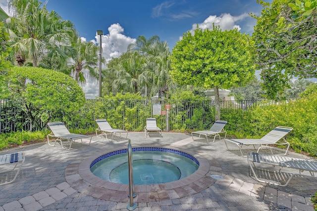 view of swimming pool with a patio, fence, and a hot tub