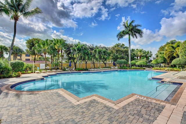 pool featuring fence and a patio