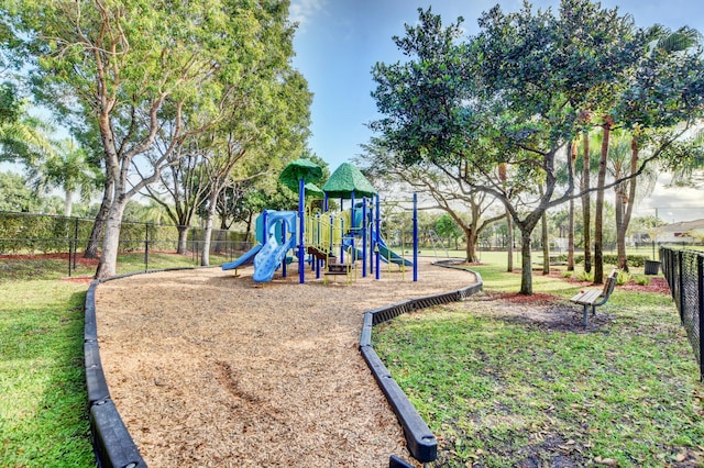 community jungle gym with fence and a lawn