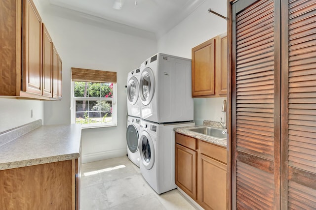 15082 Tall Oak Ave, Delray Beach, FL 33446 - laundry area with a sink, stacked washer and dryer, cabinet space, and baseboards