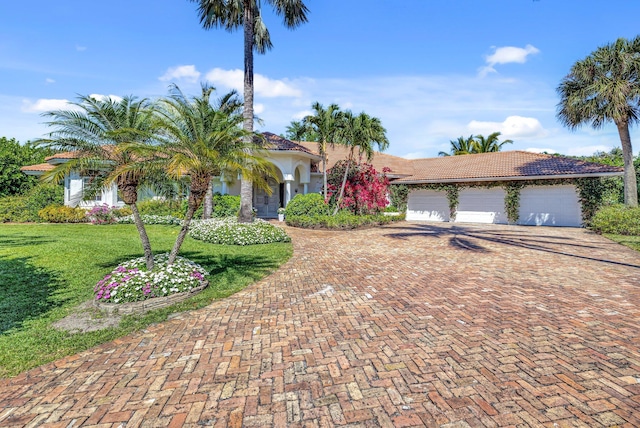 15082 Tall Oak Ave, Delray Beach, FL 33446 - mediterranean / spanish house with stucco siding, a tiled roof, decorative driveway, a front yard, and a garage