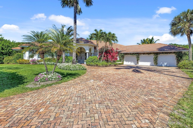 15082 Tall Oak Ave, Delray Beach, FL 33446 - view of front of home with decorative driveway, an attached garage, a front yard, a tile roof, and stucco siding