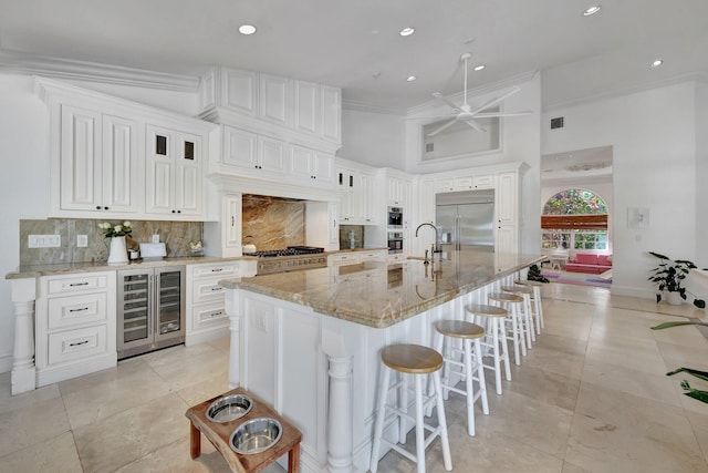 15082 Tall Oak Ave, Delray Beach, FL 33446 - kitchen featuring light stone countertops, stainless steel appliances, tasteful backsplash, and beverage cooler