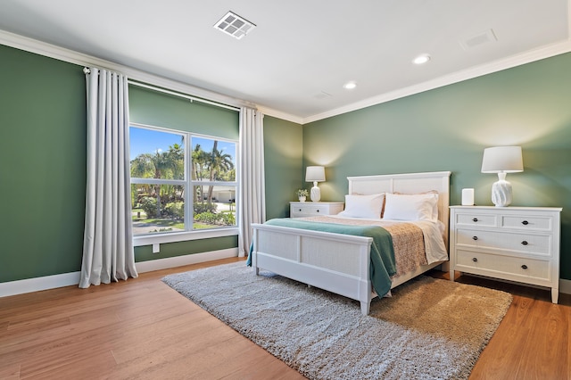 bedroom with crown molding, baseboards, wood finished floors, and recessed lighting